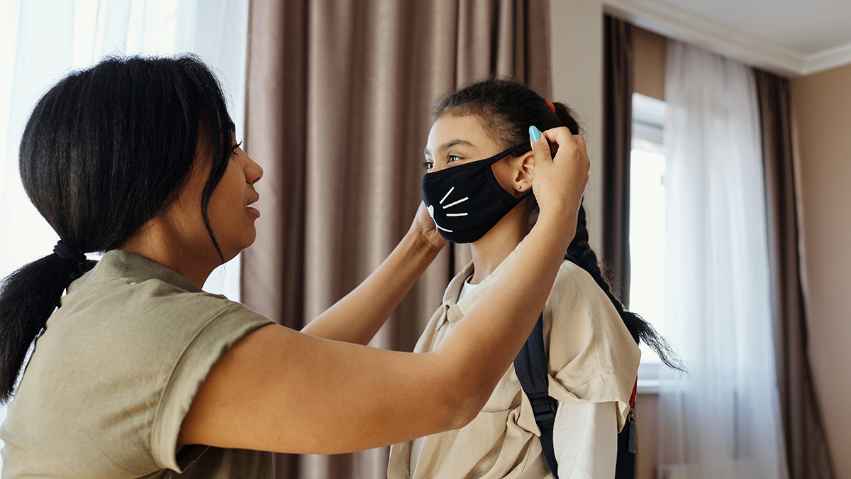 mother fitting mask onto daughter